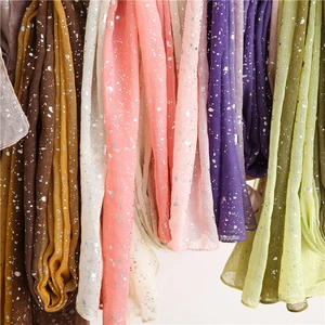 Detail of multi-color cotton linen scarves featuring delicate silver foil star patterns