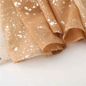 Detailed macro view of camel cotton linen scarf with silver foil dots and hemmed edges