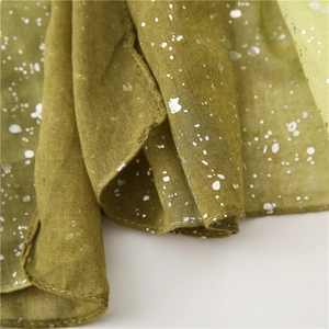 Detail of olive green cotton linen scarf with silver gradient glitter and soft texture