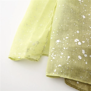 Detailed macro view of light green gradient fabric with silver foil metallic highlights