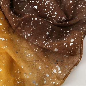 Detailed macro view of brown and yellow linen scarf with shimmering silver foil dots