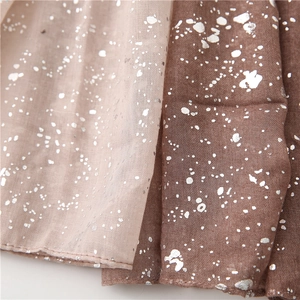 Macro detail of cotton linen scarf showing silver foil patterns and fine edge stitching