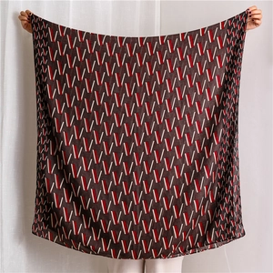 Detail view of coffee brown shawl with red and white geometric V-pattern silk texture