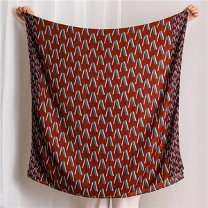Detail of red-brown shawl with blue geometric abstract patterns in light fabric