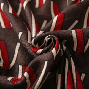Detailed close-up of soft winter scarf fabric with red and white geometric patterns