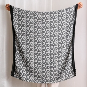 Light gray cotton linen shawl featuring black G-letter patterns and contrasting borders