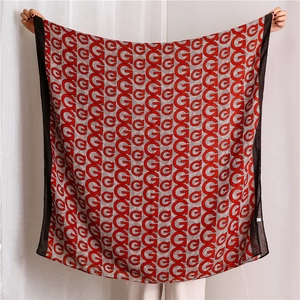 Close-up of red and white cotton linen scarf showing geometric G-letter print texture