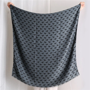 Detail of dark grey scarf featuring black pony pattern and fine fringe edges