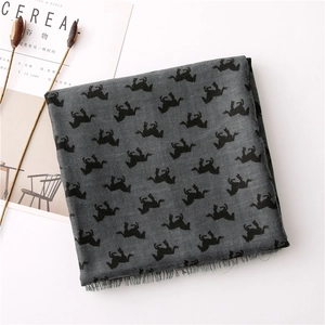 Macro shot of grey cotton linen scarf featuring black horse patterns and fringed edges
