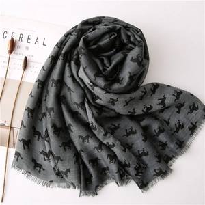 Dark grey cotton linen scarf with black horse print and fringed edges on a white table