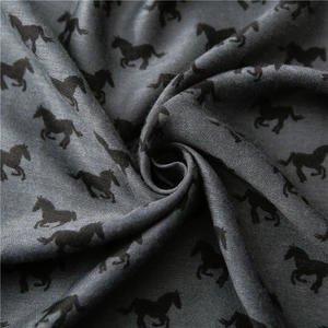 Close-up of soft grey cotton linen scarf fabric with elegant black horse print pattern