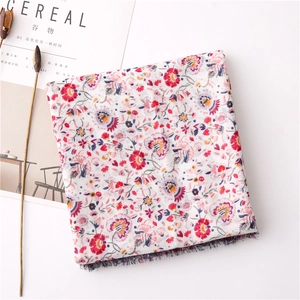 Dettaglio della sciarpa in cotone e lino a fiori con frange e stampe di petali colorati