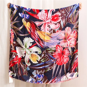Detail of floral and parrot print scarf with tropical hibiscus pattern and fringed edges