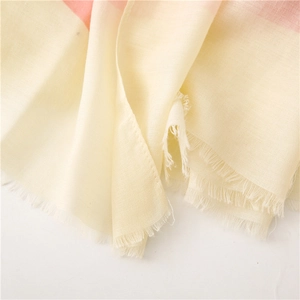 Dettaglio della sciarpa in cotone e lino beige e arancio con bordi a frange fatti a mano
