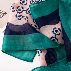 Close-up of cotton linen scarf with floral print and light breathable fabric texture