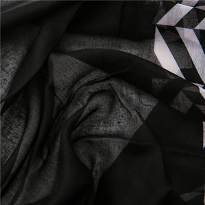 Close-up of lightweight black and white geometric pattern scarf with sheer texture