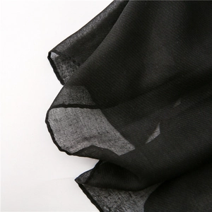 Detailed macro view of lightweight black semi-transparent chiffon scarf fabric with soft texture