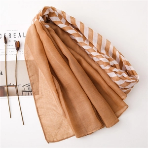 Detail of lightweight brown and white striped scarf with refined rolled edges