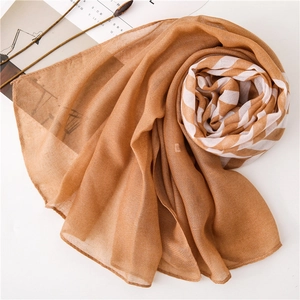 Detailed view of camel striped scarf with soft lightweight fabric in spiral fold display