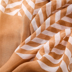 Detail shot of lightweight chiffon scarf featuring brown and white chevron geometric patterns