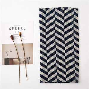 Close-up of navy blue and white zigzag pattern scarf on a minimalist table