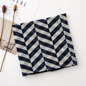 Detail of blue and white herringbone pattern scarf with natural linen texture and soft light