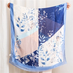 Pastel cotton linen scarf with floral print and frayed edges shown in a full-spread view