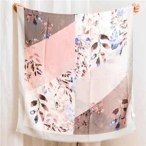 Detail of floral printed linen scarf featuring geometric color blocks and fringe edges