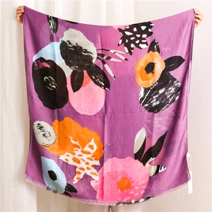 Detail of purple artistic scarf featuring abstract floral patterns and frayed edges