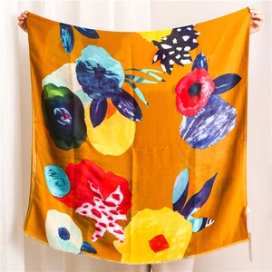Detail of colorful floral pattern on orange rectangular scarf with frayed edges