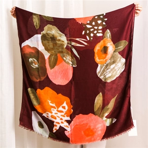 Detail of burgundy ethnic scarf with abstract floral print and delicate fringed edges