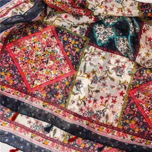 Detail of bohemian patchwork floral scarf with fringe tassels and vibrant patterns