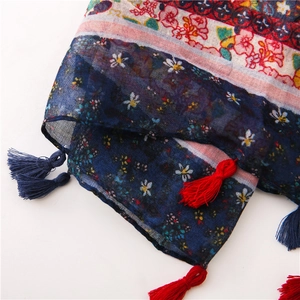 Detail of bohemian floral cotton scarf featuring dark blue print and contrast tassels