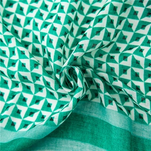 Nahaufnahme des geometrischen Diamantmusters auf Baumwoll-Leinen-Schal in Grün und Weiß
