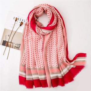 Detailansicht des Schals mit geometrischem Muster, rosa Farbtönen und feinen Fransen