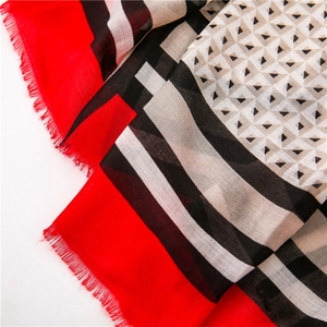Detailansicht des geometrischen Schals mit rot-schwarzen Streifen und Fransenrand