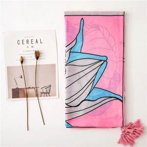 Detail of pink cotton linen scarf featuring blue butterfly patterns and decorative tassels