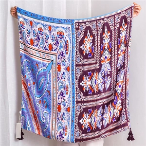 Dettaglio di scialle effetto seta con motivo paisley, nappe viola e disegni floreali