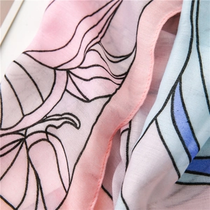 Detail of floral linen scarf showing fine texture and delicate stitching at the edge