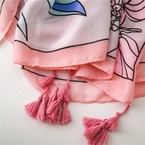 Close-up of floral cotton linen scarf featuring pink fringe trim and soft petal pattern
