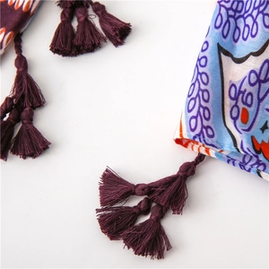 Dettaglio dello scialle bohémien in cotone e lino con nappe viola e motivi floreali blu