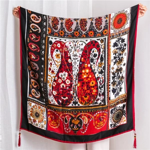 Detail of paisley patterns and decorative red tassels on cotton linen ethnic shawl
