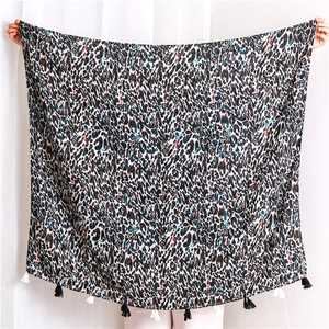 Détail d'écharpe en coton et lin à imprimé léopard avec des accents colorés et des franges