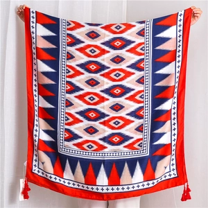 Detail of geometric diamond print and handmade tassels on red and blue cotton linen scarf