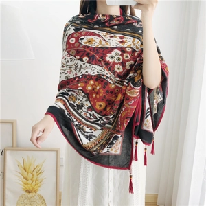 Close-up of bohemian paisley cotton linen shawl with handmade wooden bead tassels