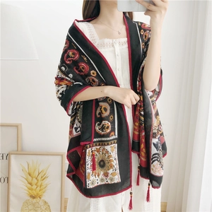 Close-up of bohemian paisley cotton linen shawl with red beaded tassels and fringes
