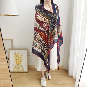 Detail of bohemian paisley shawl showing rich floral patterns and red tassel fringe