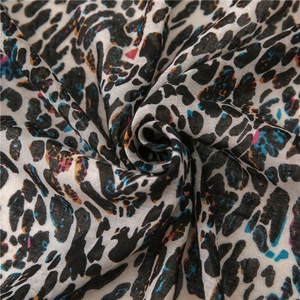Gros plan sur le tissu d'écharpe imprimé léopard coloré avec une texture tissée douce en spirale