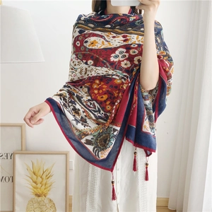Detail of paisley cotton linen shawl featuring handmade wooden beads and red tassels