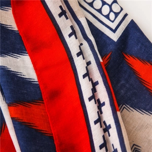 Close-up of red and blue geometric patterns on cotton linen scarf with soft folds